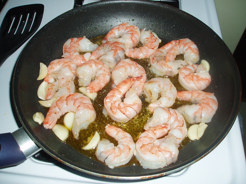 a set filled with shrimp in oil on a stove