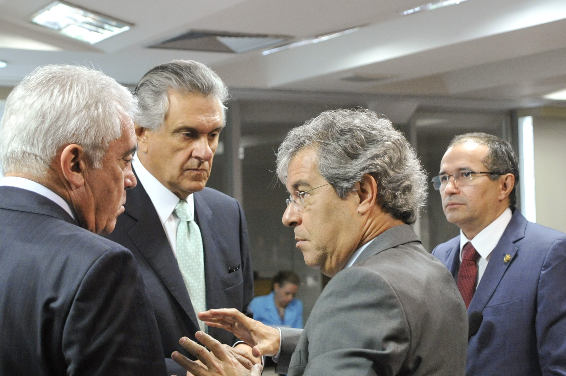 men standing in a room talking with each other