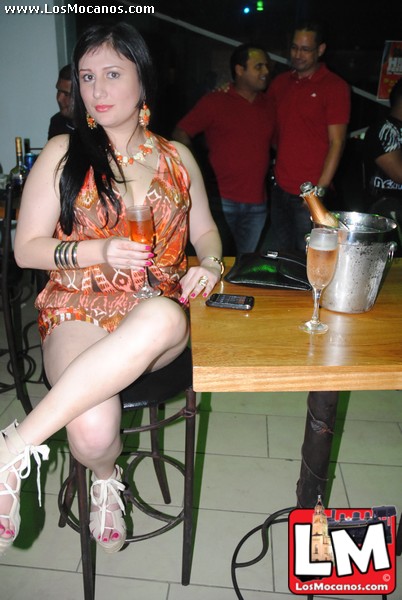 a woman in short shorts is sitting down at a table