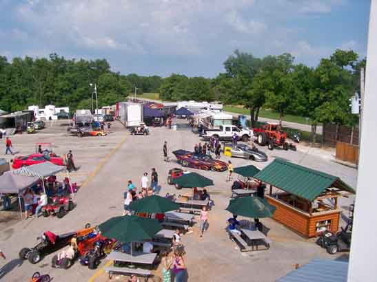 an outdoor festival with lots of cars parked in the lot