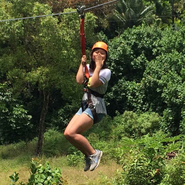 a woman is hanging from a zip line during an outing