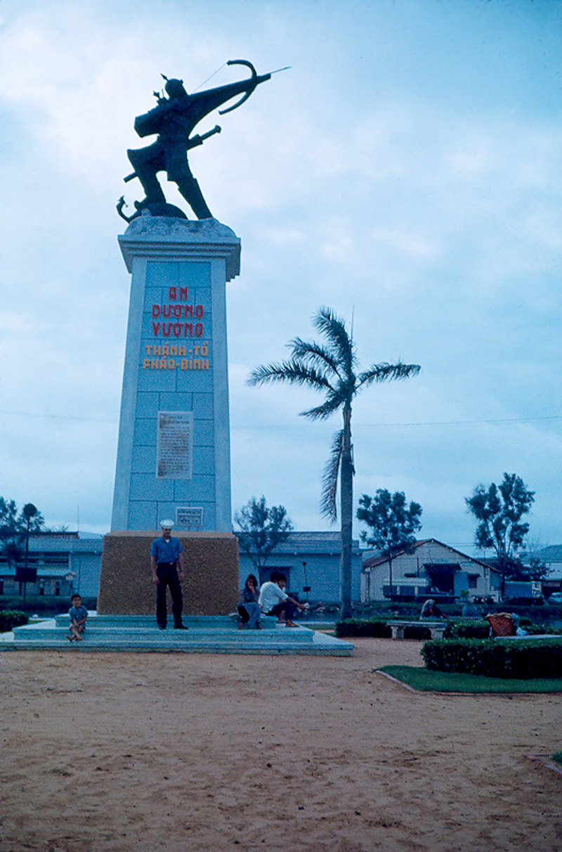 man standing in front of monument near palm trees