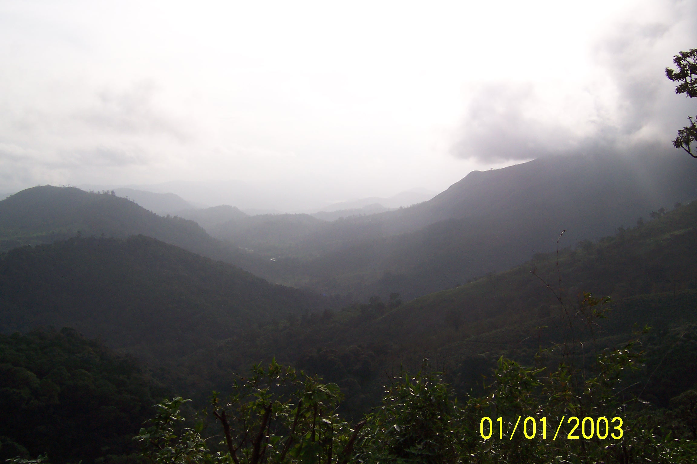 some clouds over mountains in a misty weather