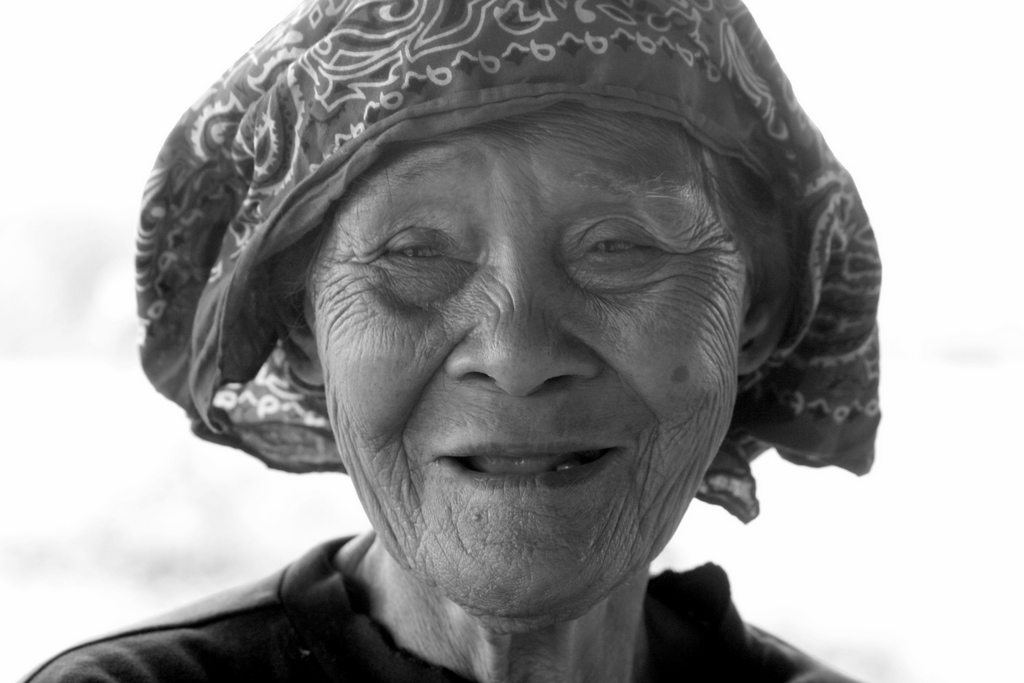 a woman smiling wearing a hat with a large pattern