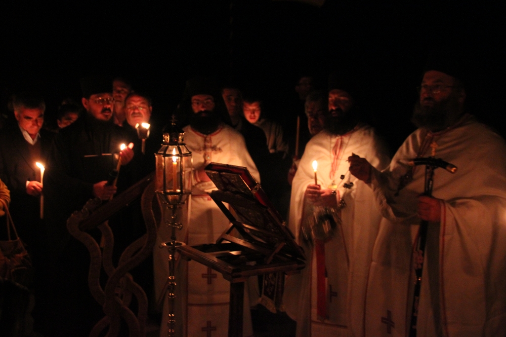 a bunch of people with candles stand near each other