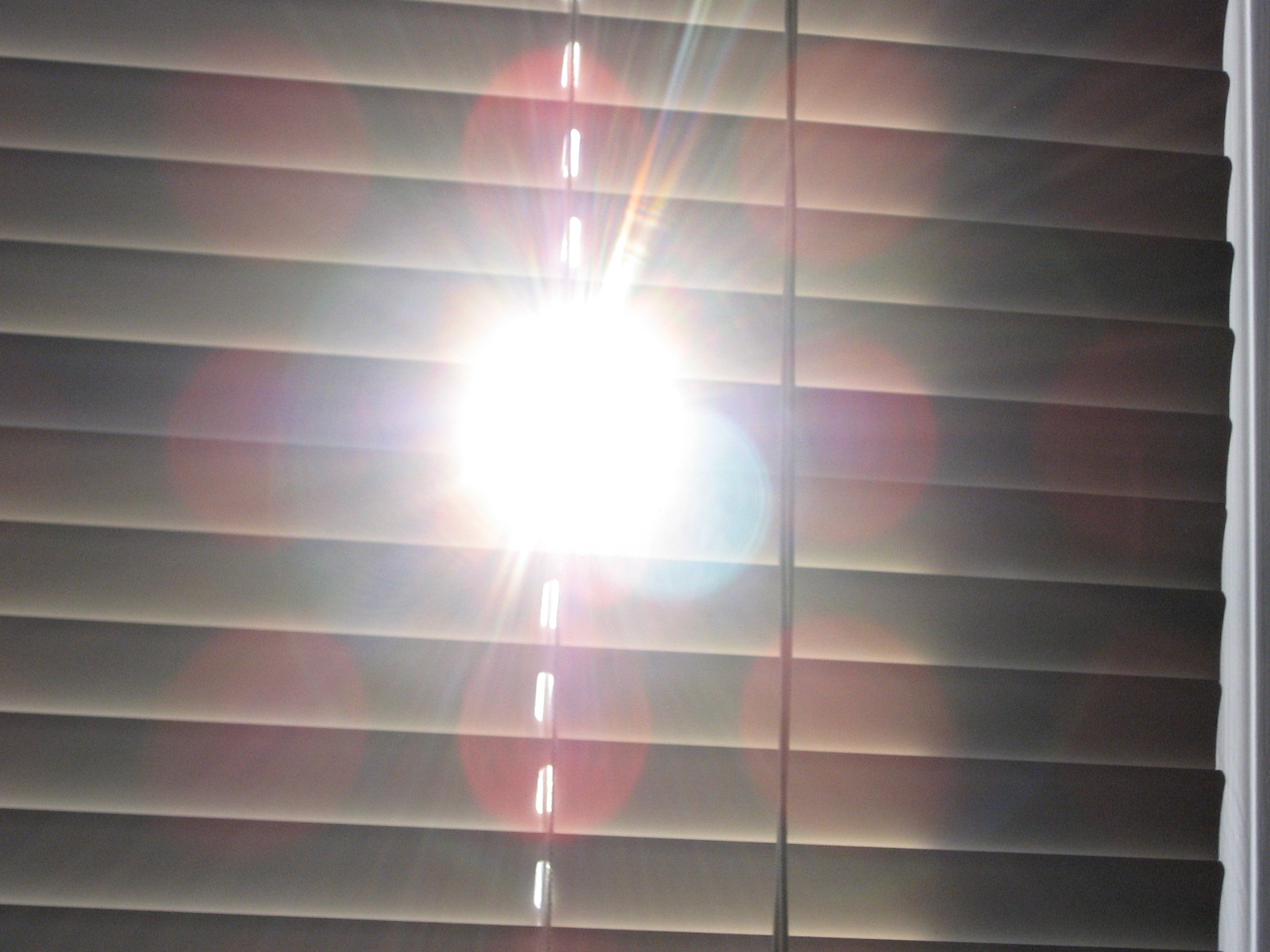 the sun shining through blinds in the bathroom