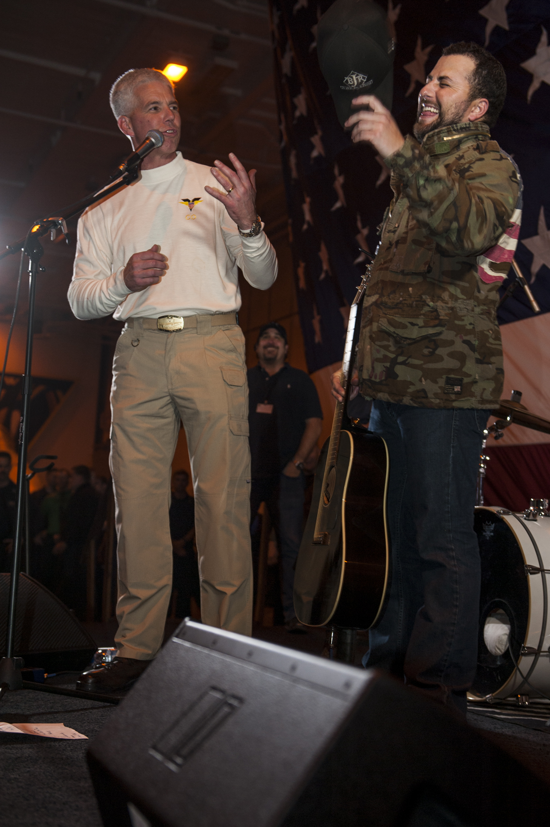 two guys are talking and singing on stage