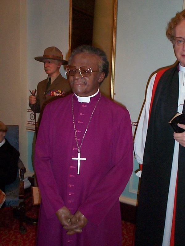 the man in the purple robe is posing for the picture with the priest