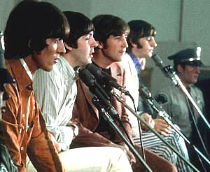 a group of people standing and sitting in front of microphones