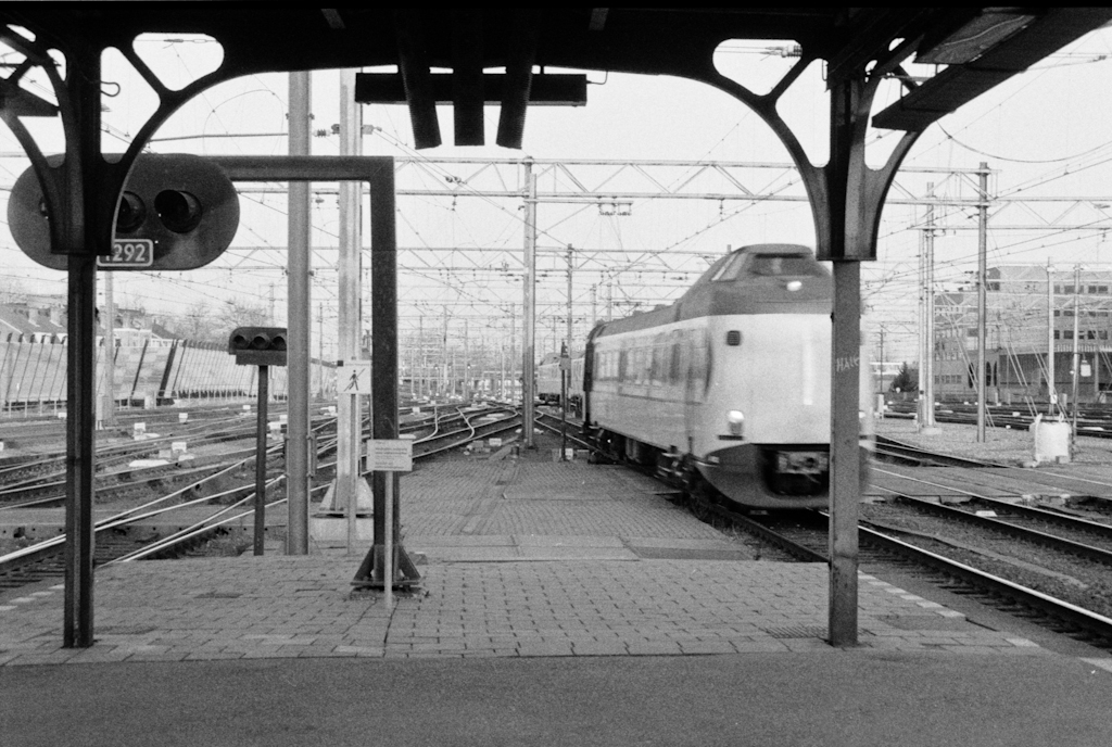 a passenger train traveling through a station next to a platform