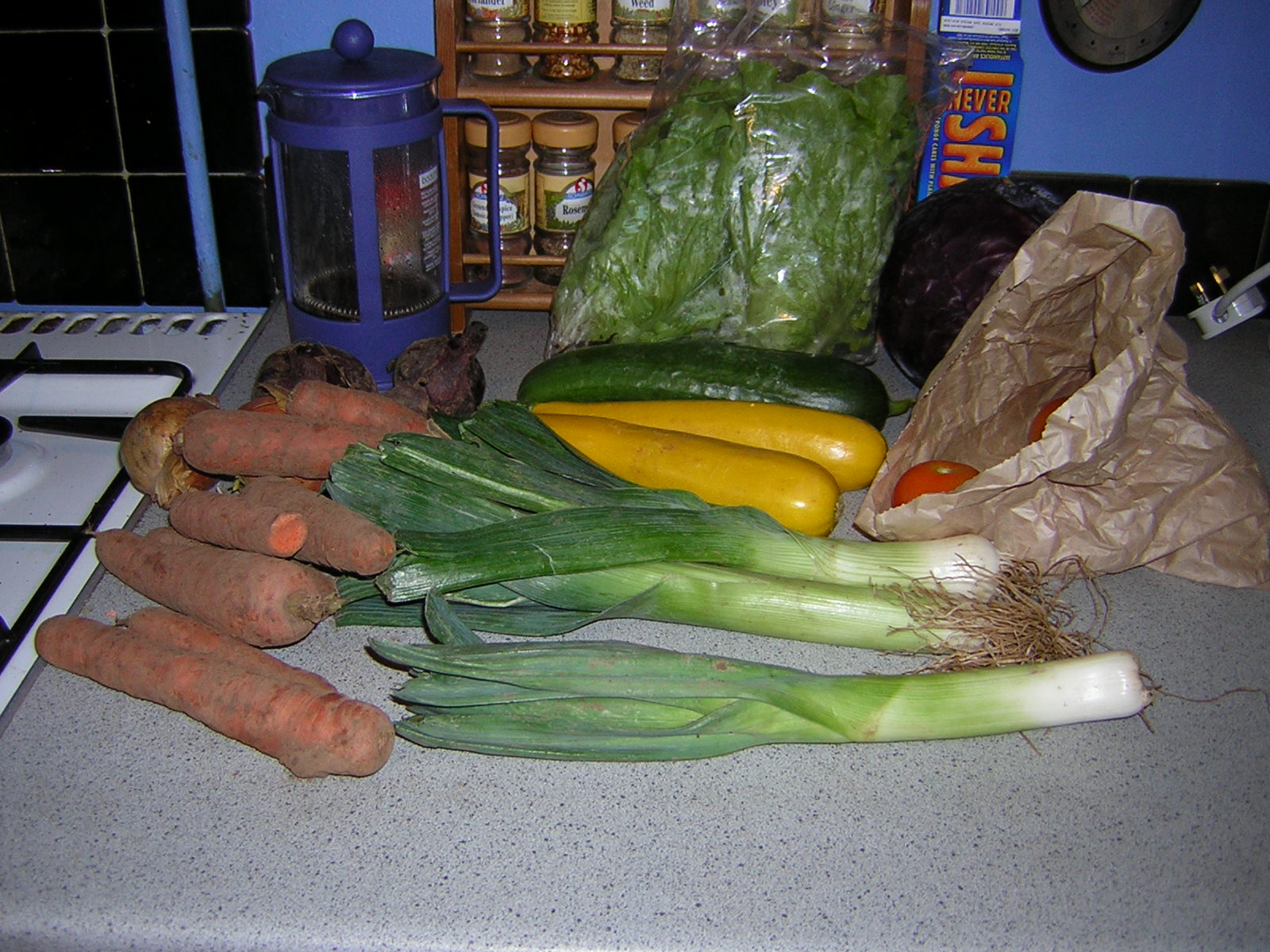 many vegetables, including carrots and leeks, sit on a counter