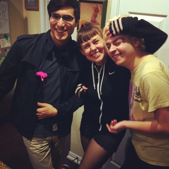 four people standing together in a kitchen and posing for a po