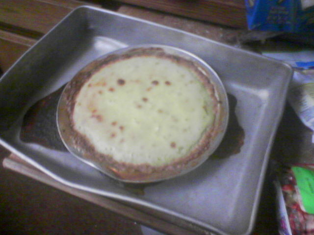 there is a pizza pie in the pan on the stove