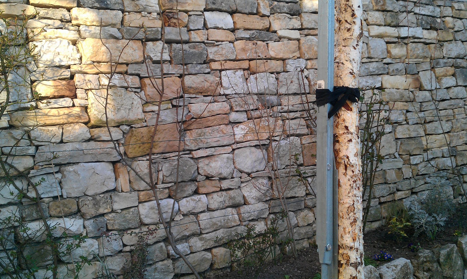 there is a fence made of stones and a wooden post