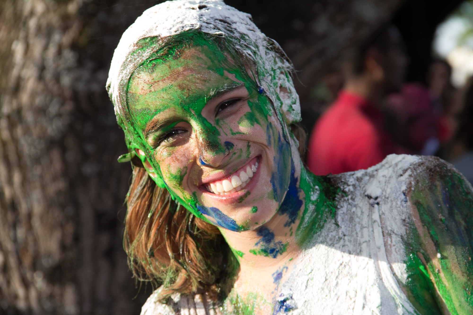 a girl with green paint all over her body and head