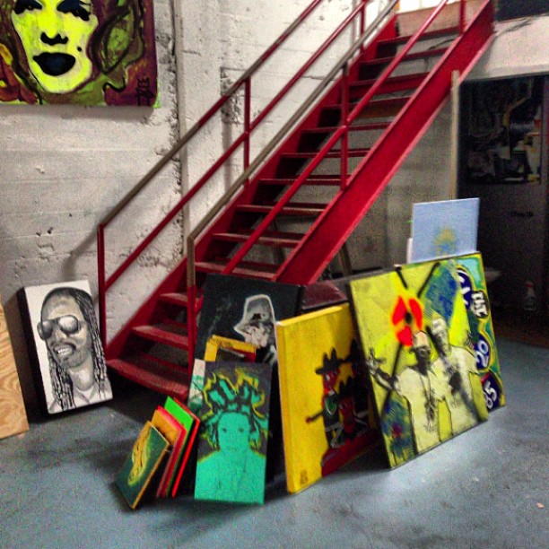 several art pieces hang up near a stairwell