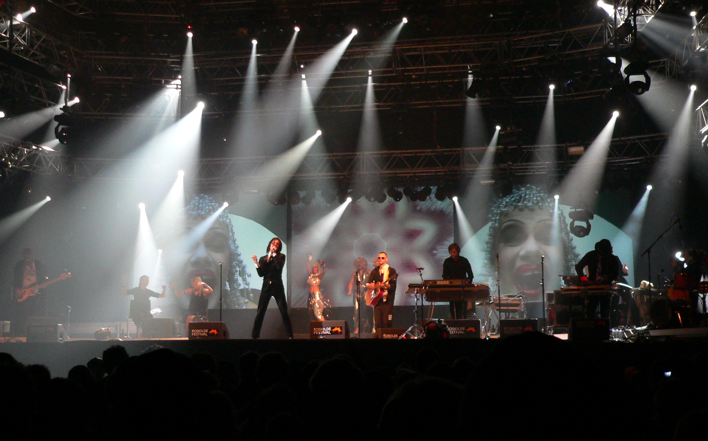 a band on stage, during a concert with white and blue lights