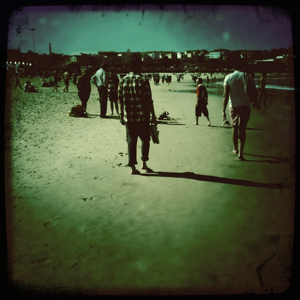 a group of people are standing on the beach