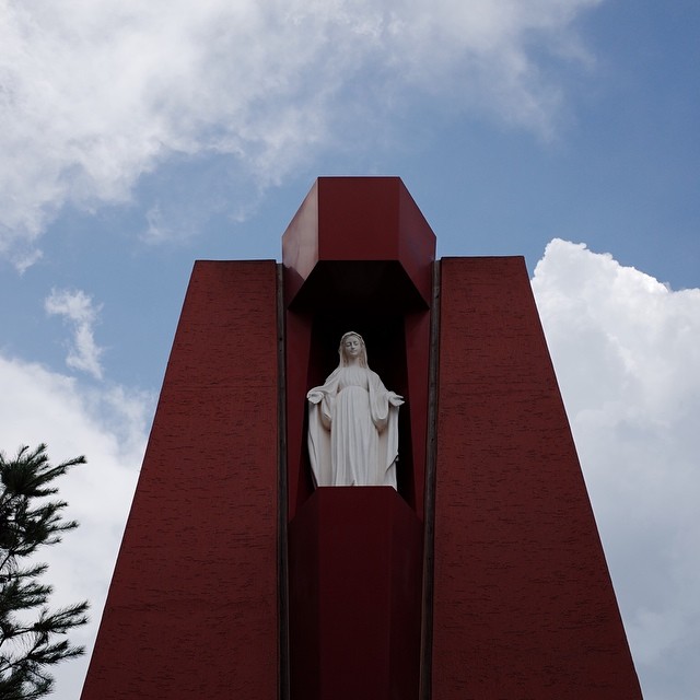 a statue of jesus is standing in the doorway of a red building
