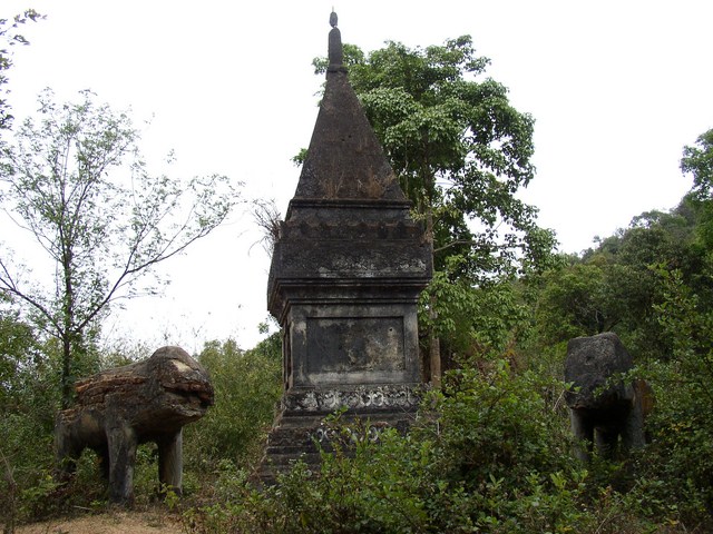 there are two elephants standing near a grave