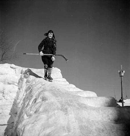 an old po of a person holding skis while standing on a snowy mountain