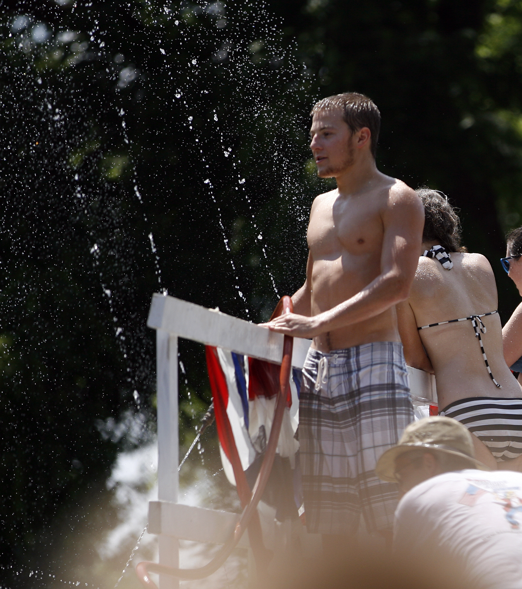 a man and woman standing in front of a flag being soaked by a jet