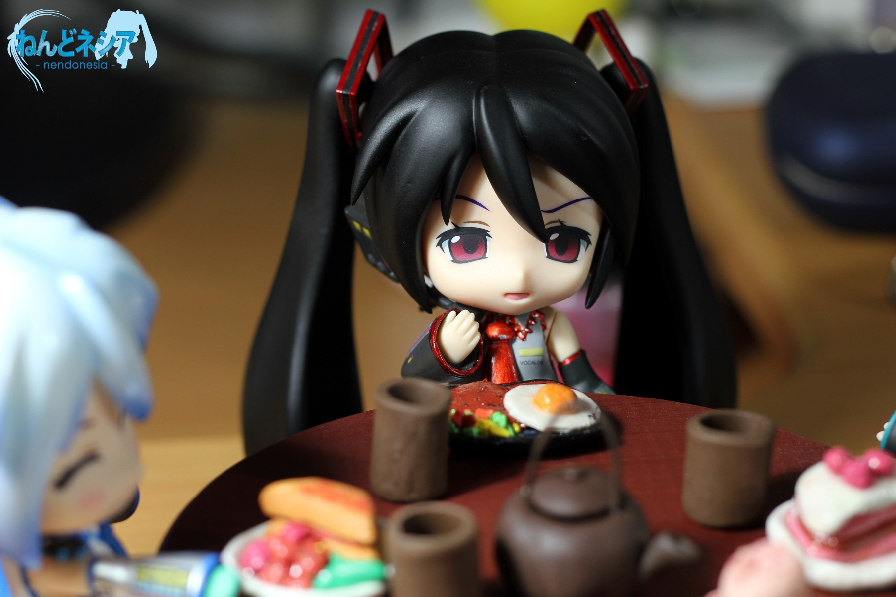 an anime figurine sitting next to several small plates
