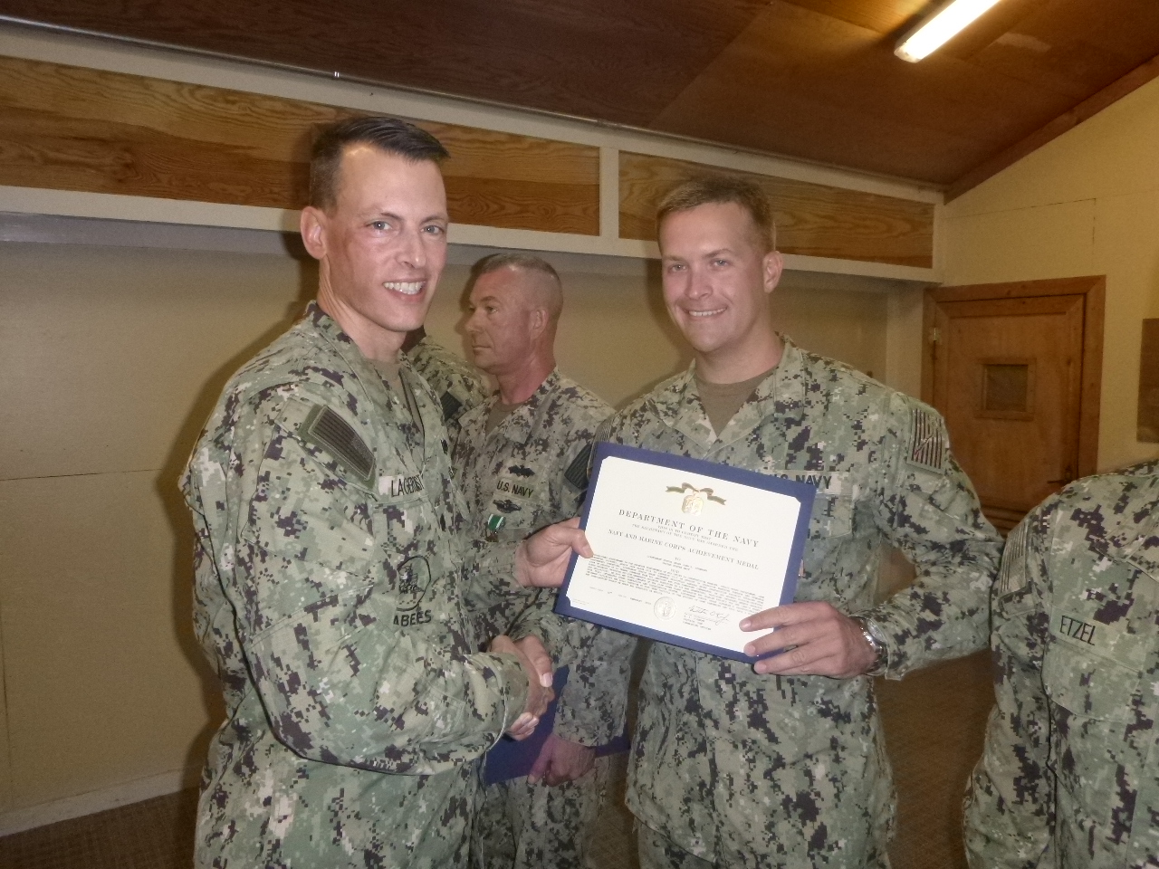 some soldiers are smiling and holding a certificate