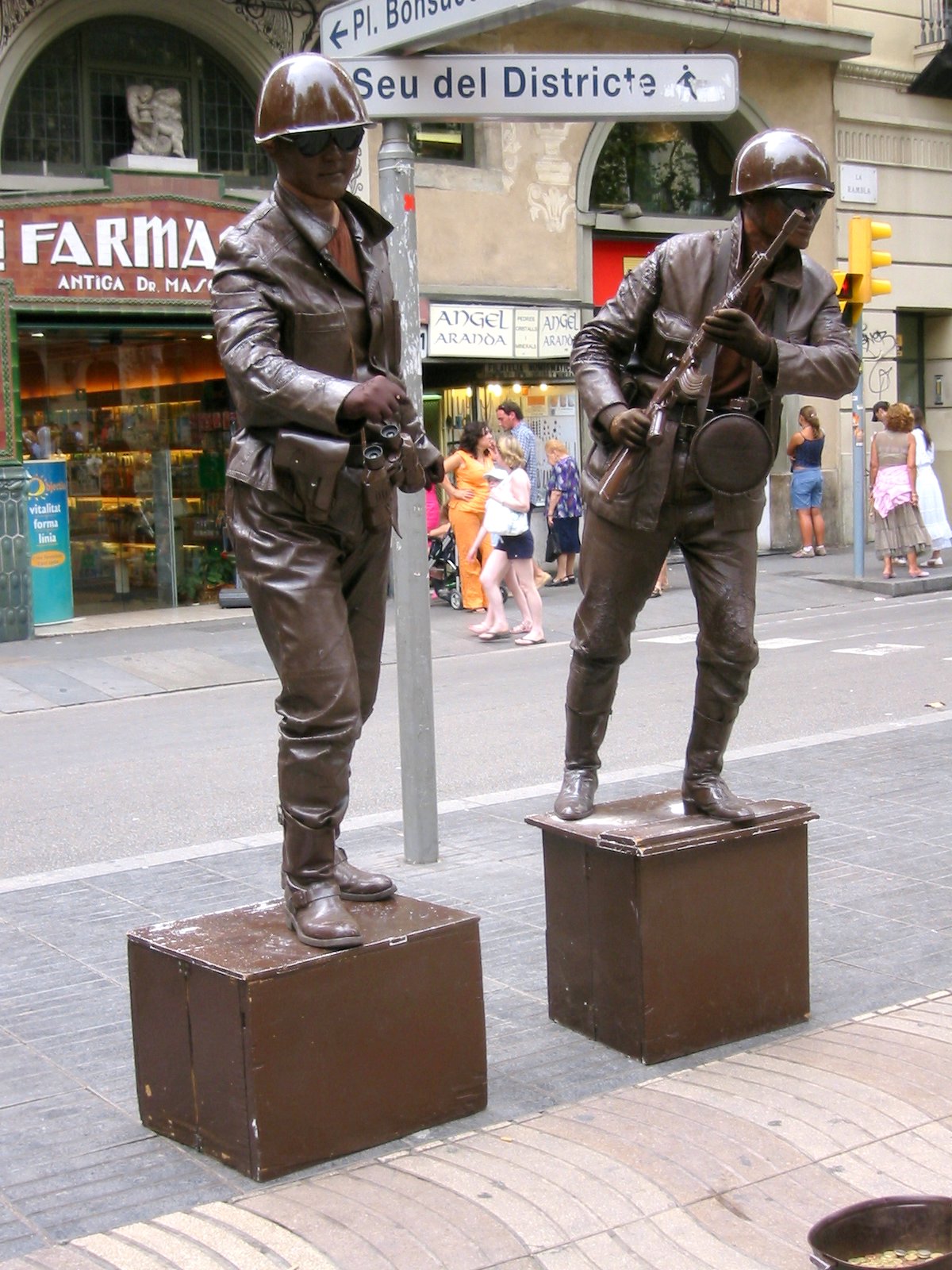 two statues of two soldiers are near a street sign