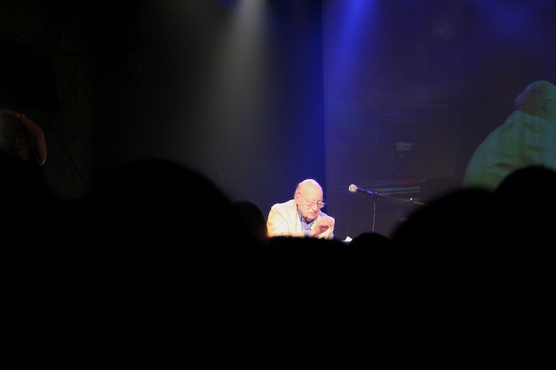 the man is speaking into a microphone in front of a crowd