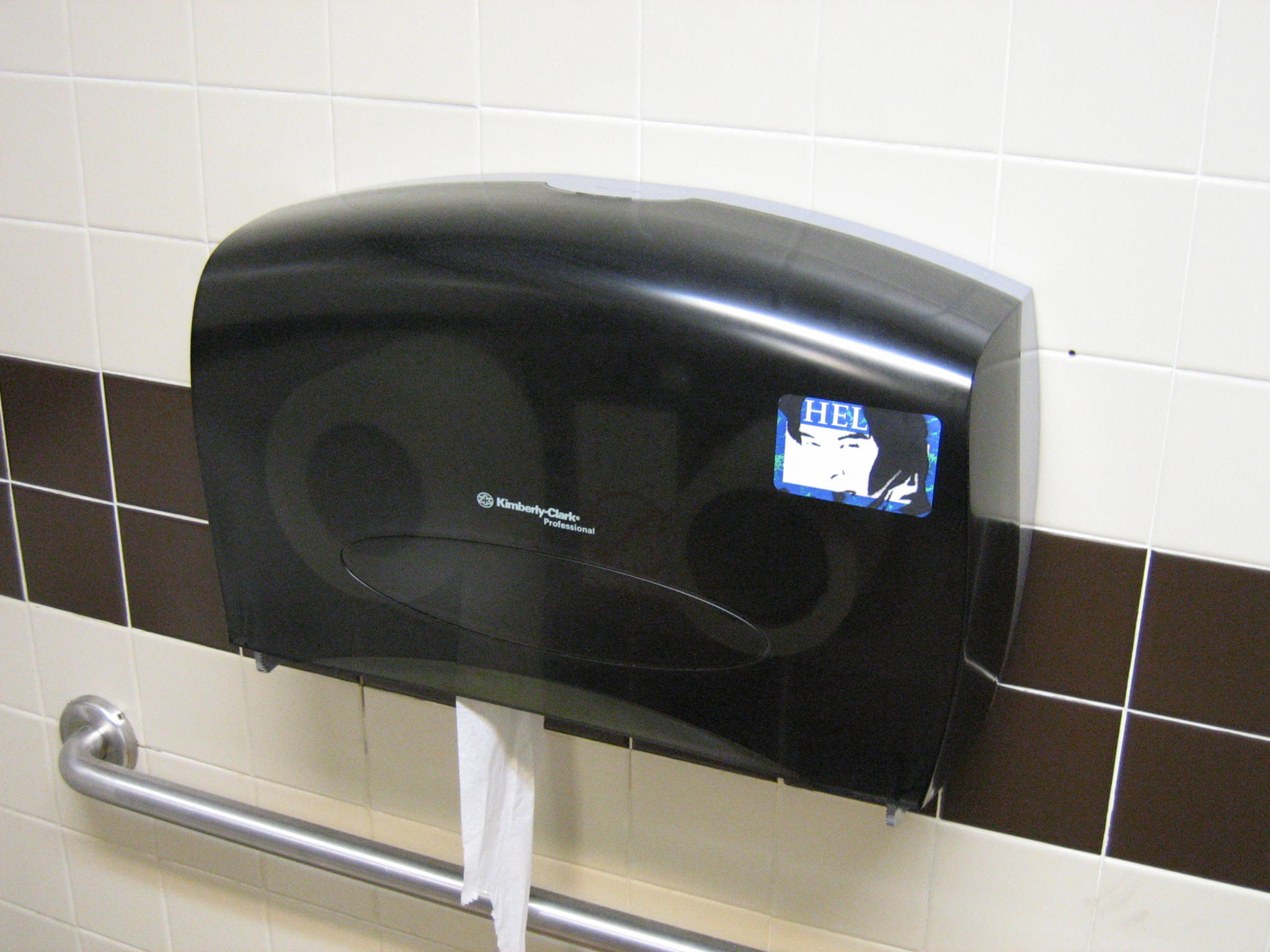 a black urinal is mounted to a wall with a blue sign that says vote