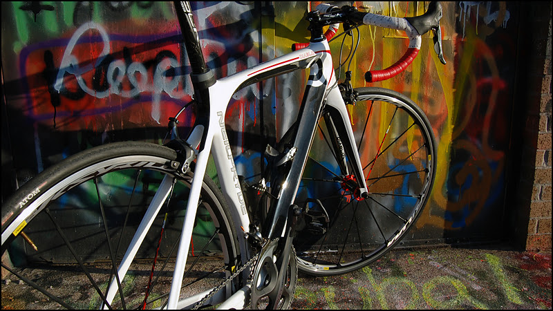 a bike leans against a graffiti covered wall