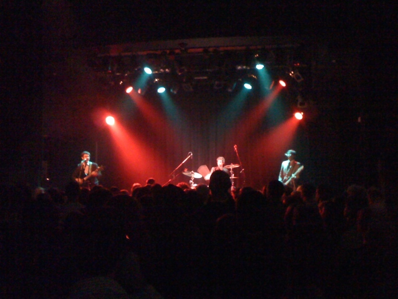 people standing around a stage in front of a band