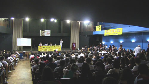 a crowd at an event watching two people speaking