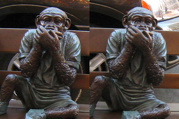 two statues of men sitting on top of a bench