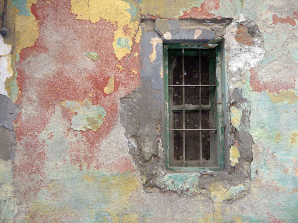 an old house with very rusty paint and green window