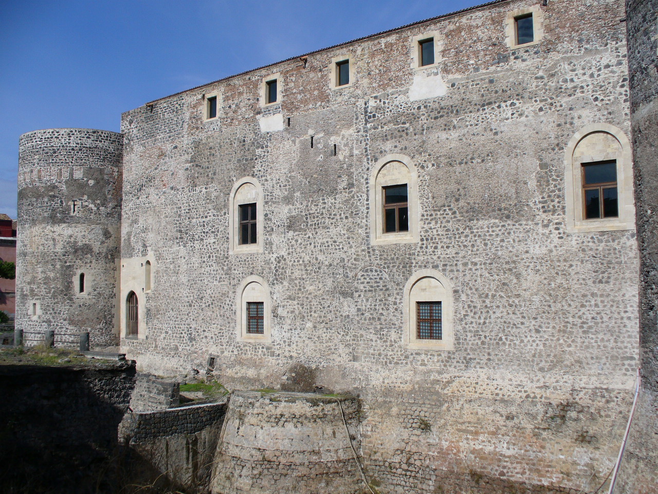 the front of a brick wall with six windows