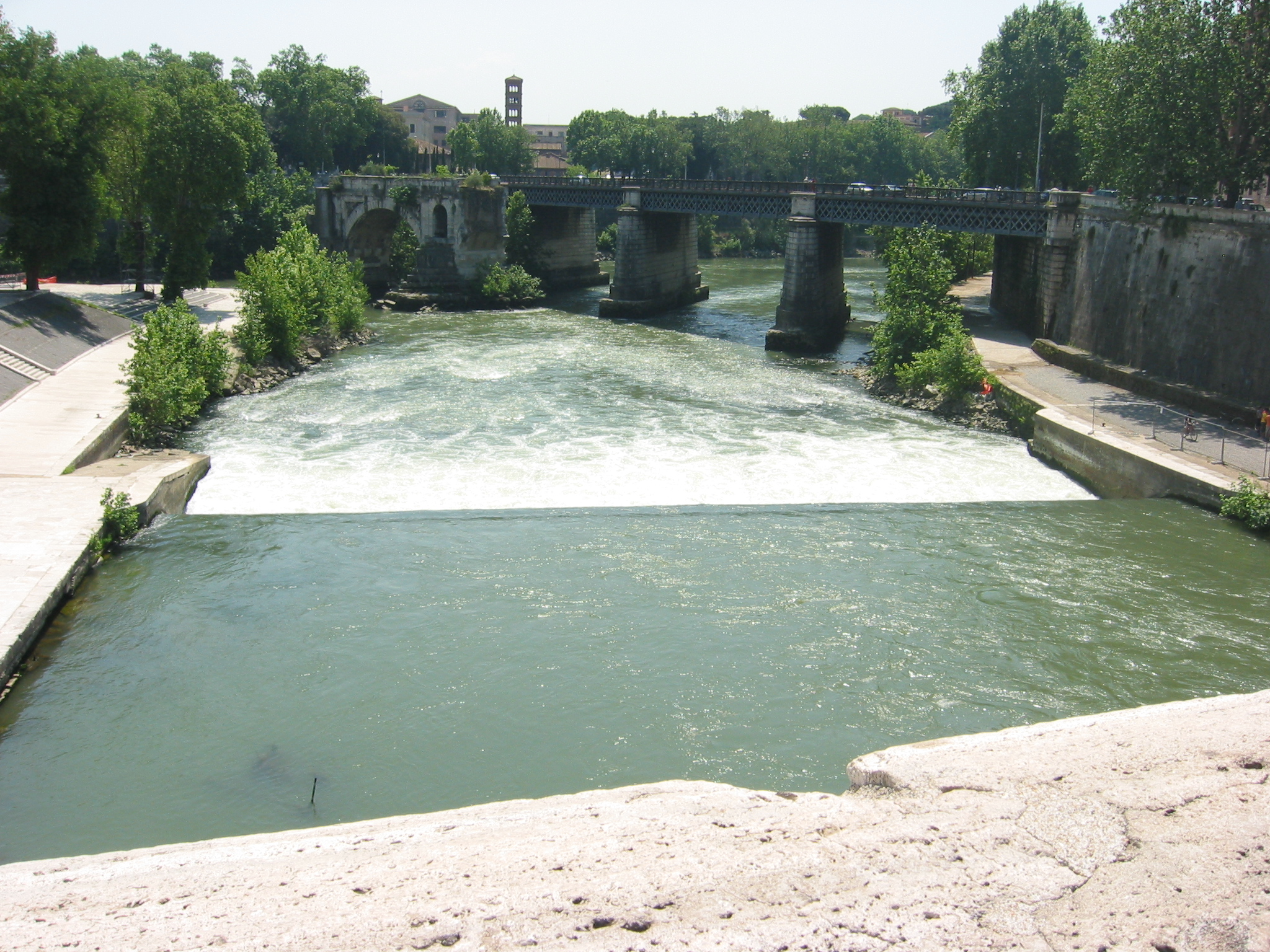 an artificial river has a bridge and some buildings near by