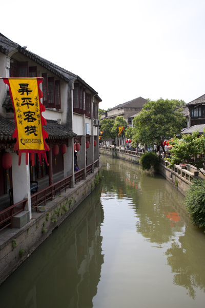 an old town along the river with a yellow sign on the door