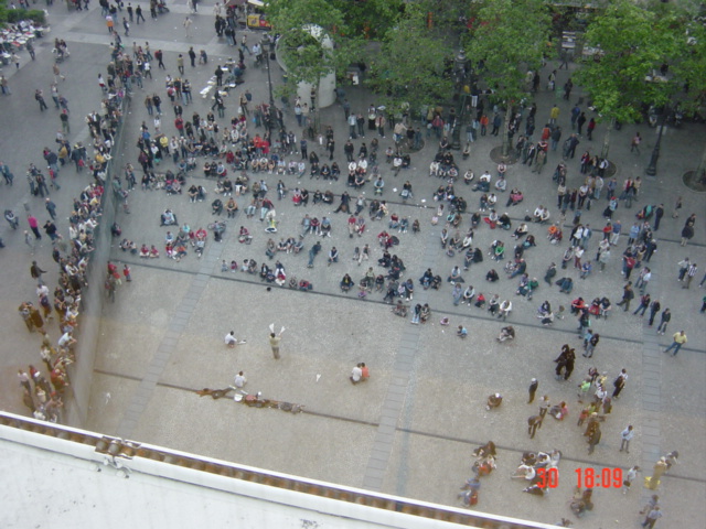 a group of people standing outside on the side of a building