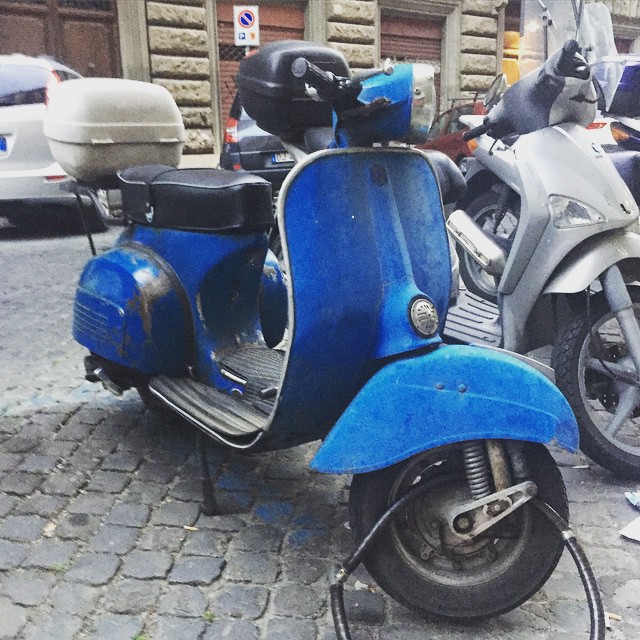 this is an image of blue motor scooter on the street