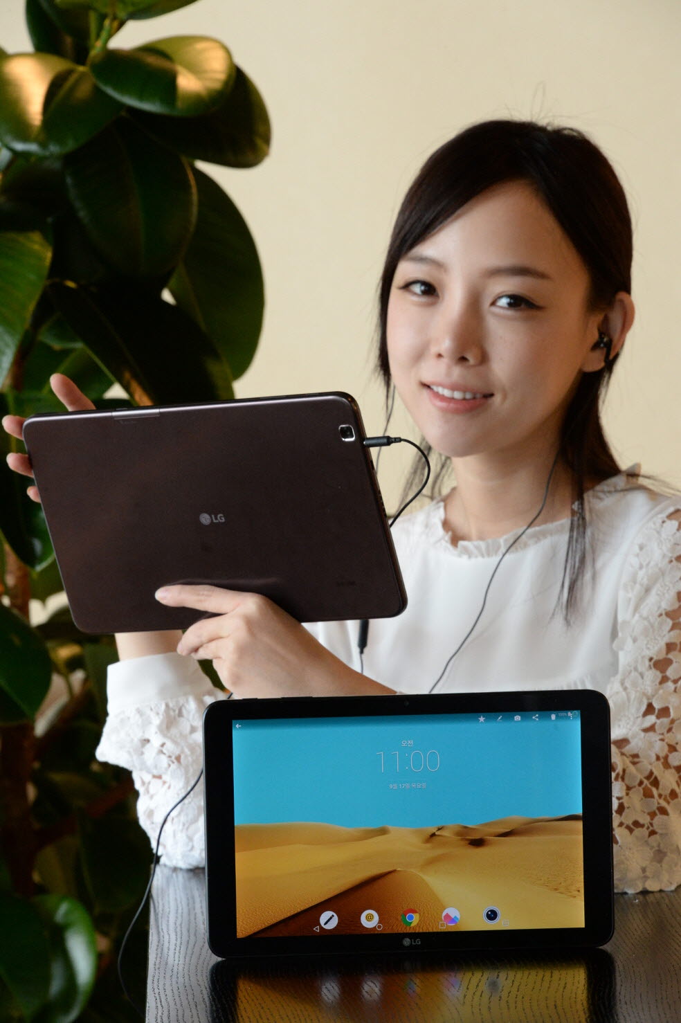 a woman in a white top holding a tablet