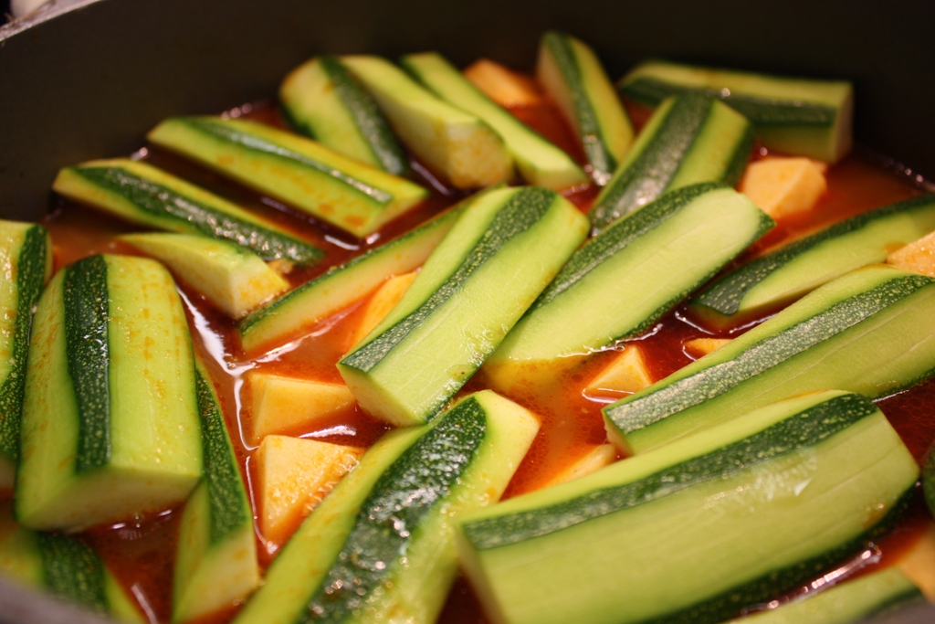 a bunch of cucumbers cooking in a sauce