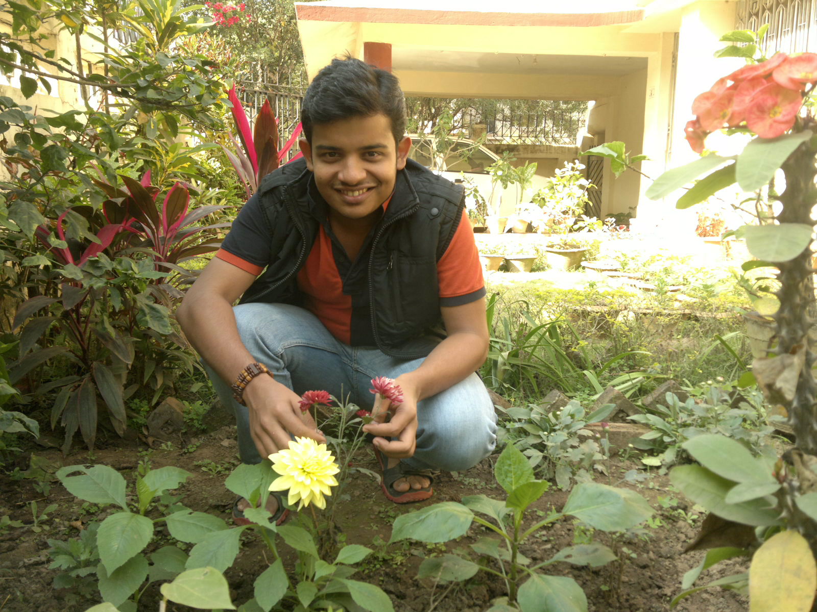 a man squats in the middle of a garden