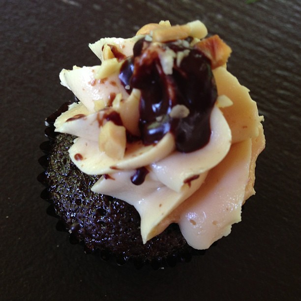 a cupcake with a fancy chocolate topping is displayed