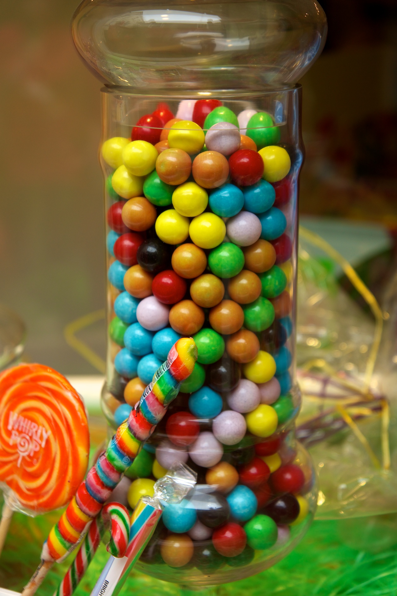 colorful candy in a glass vase with a candy cane