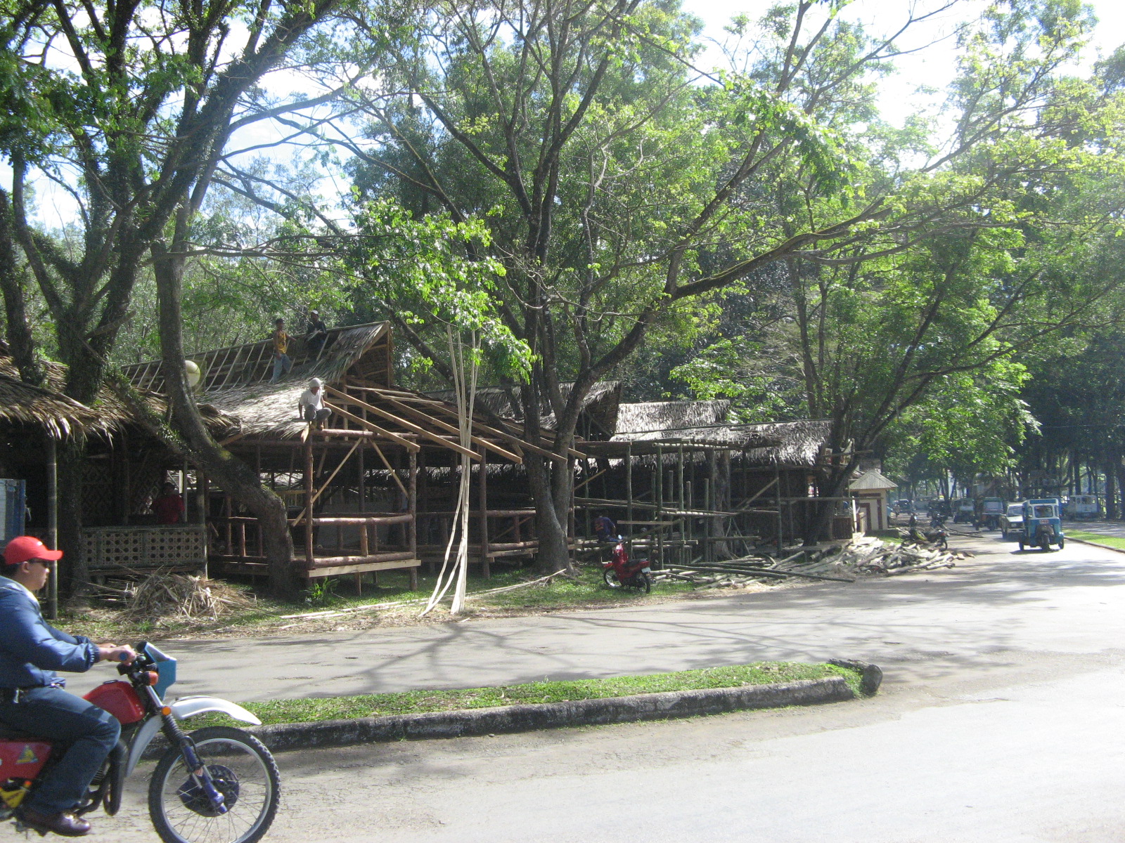 man on bicycle in front of wooden houses