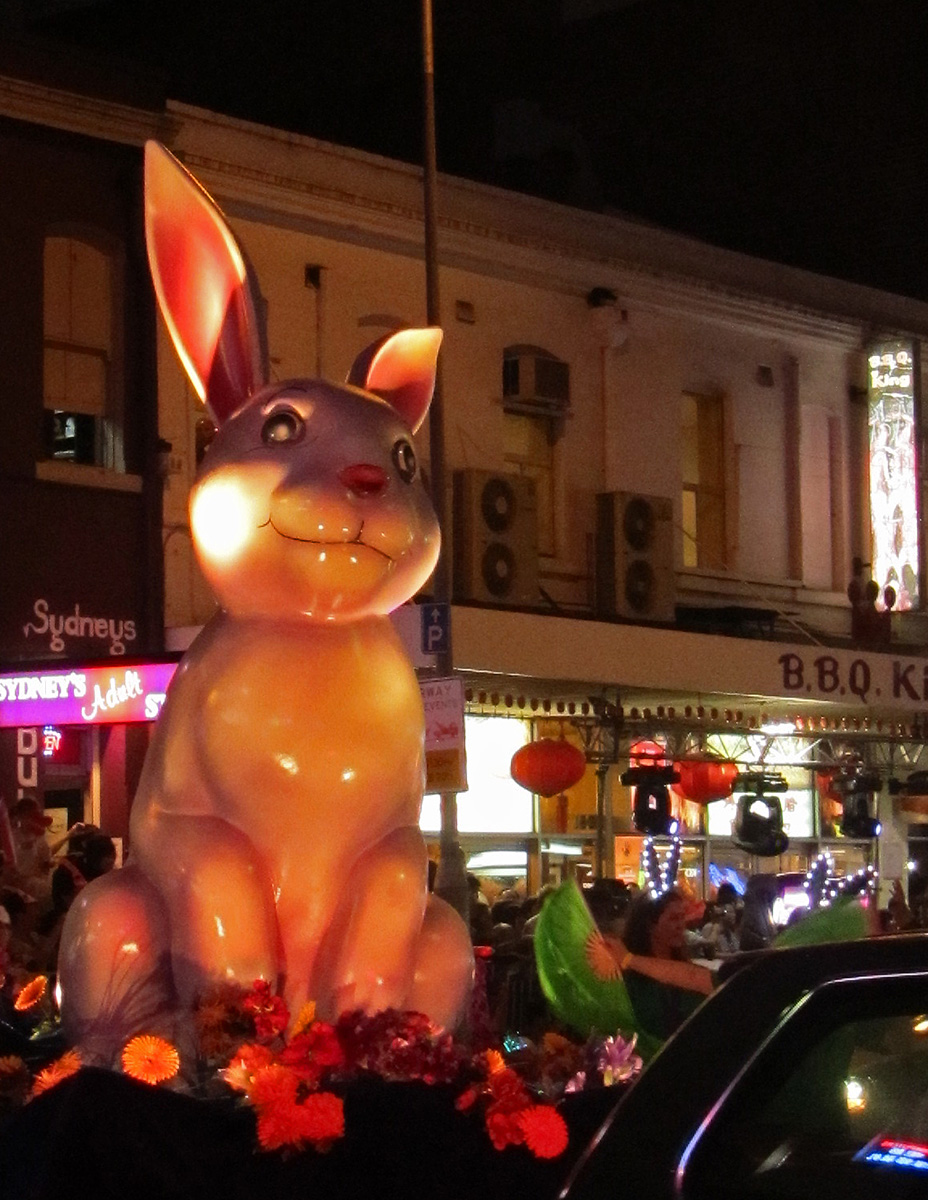 a statue of a bunny sitting next to cars