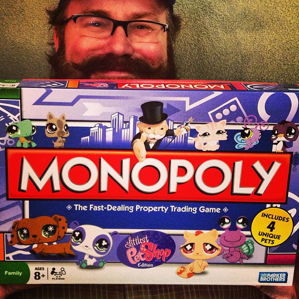 a man is holding up his monopoly board game