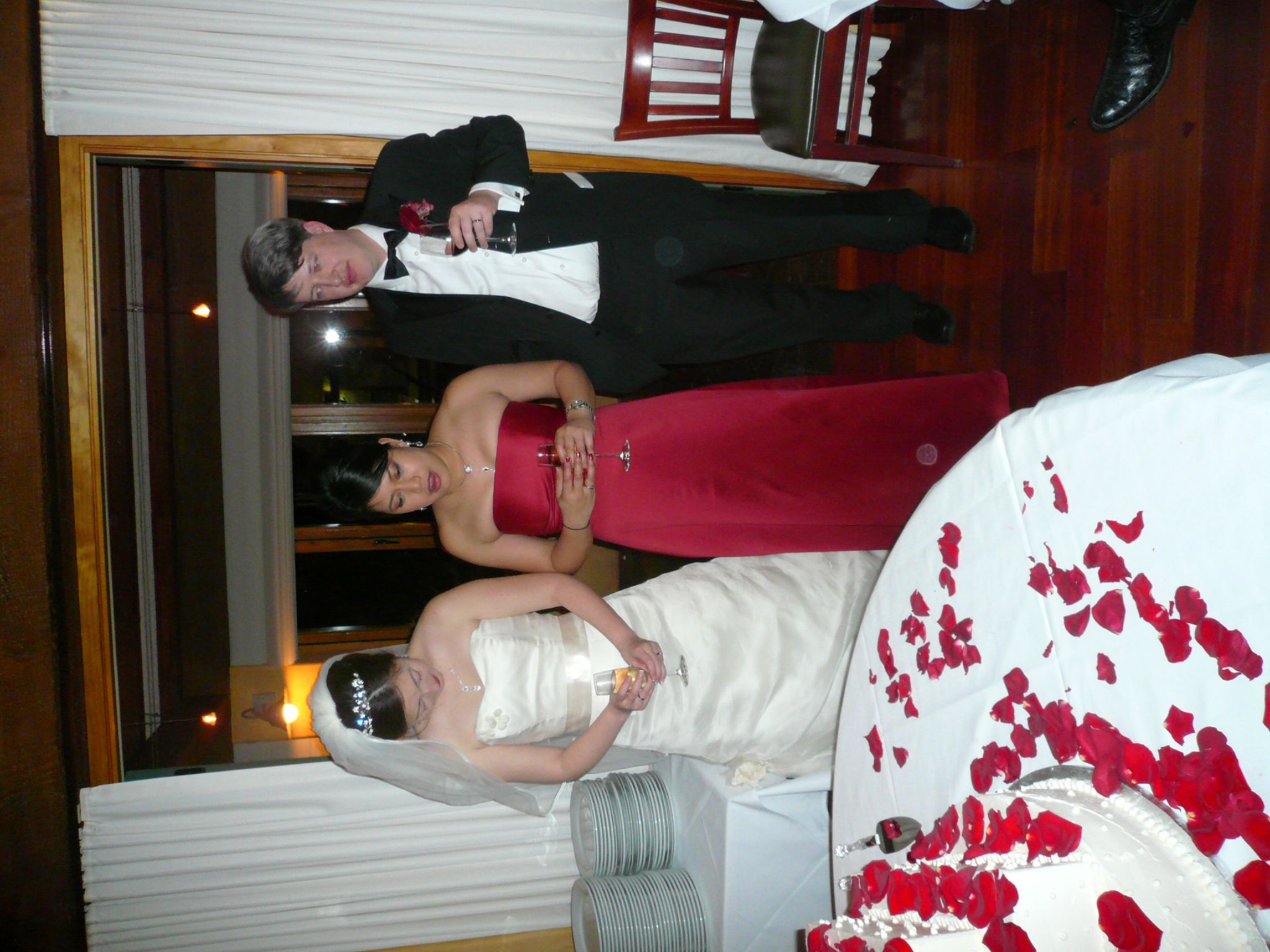 two people in formal wear standing with wine glasses